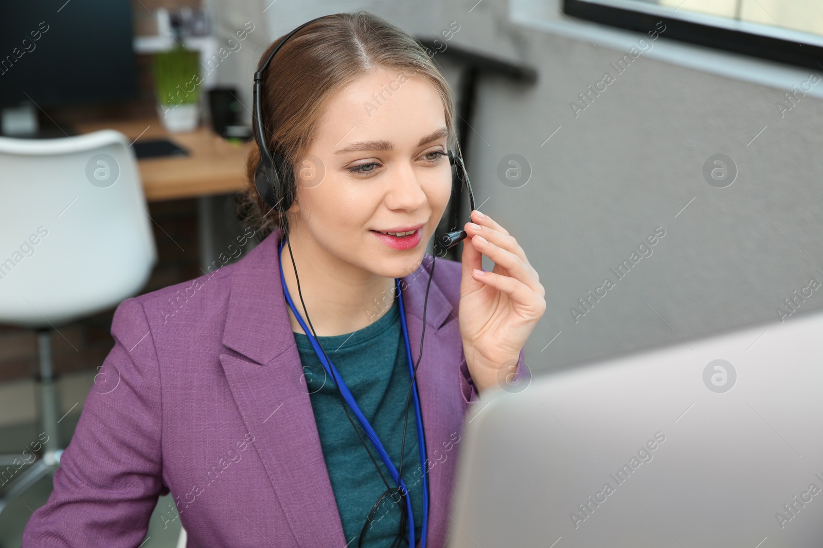 Photo of Technical support operator with headset working in office