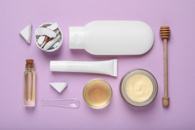 Photo of Body cream and other cosmetic products, coconut with honey on lilac background, flat lay