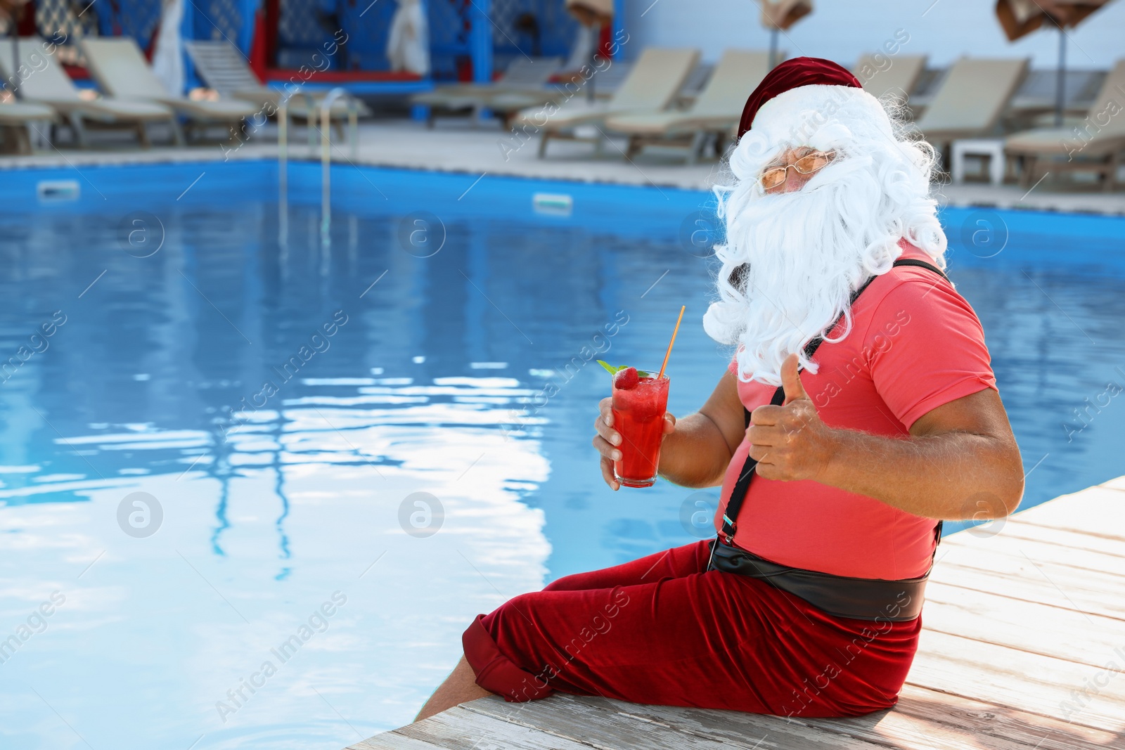 Photo of Authentic Santa Claus with cocktail near pool at resort