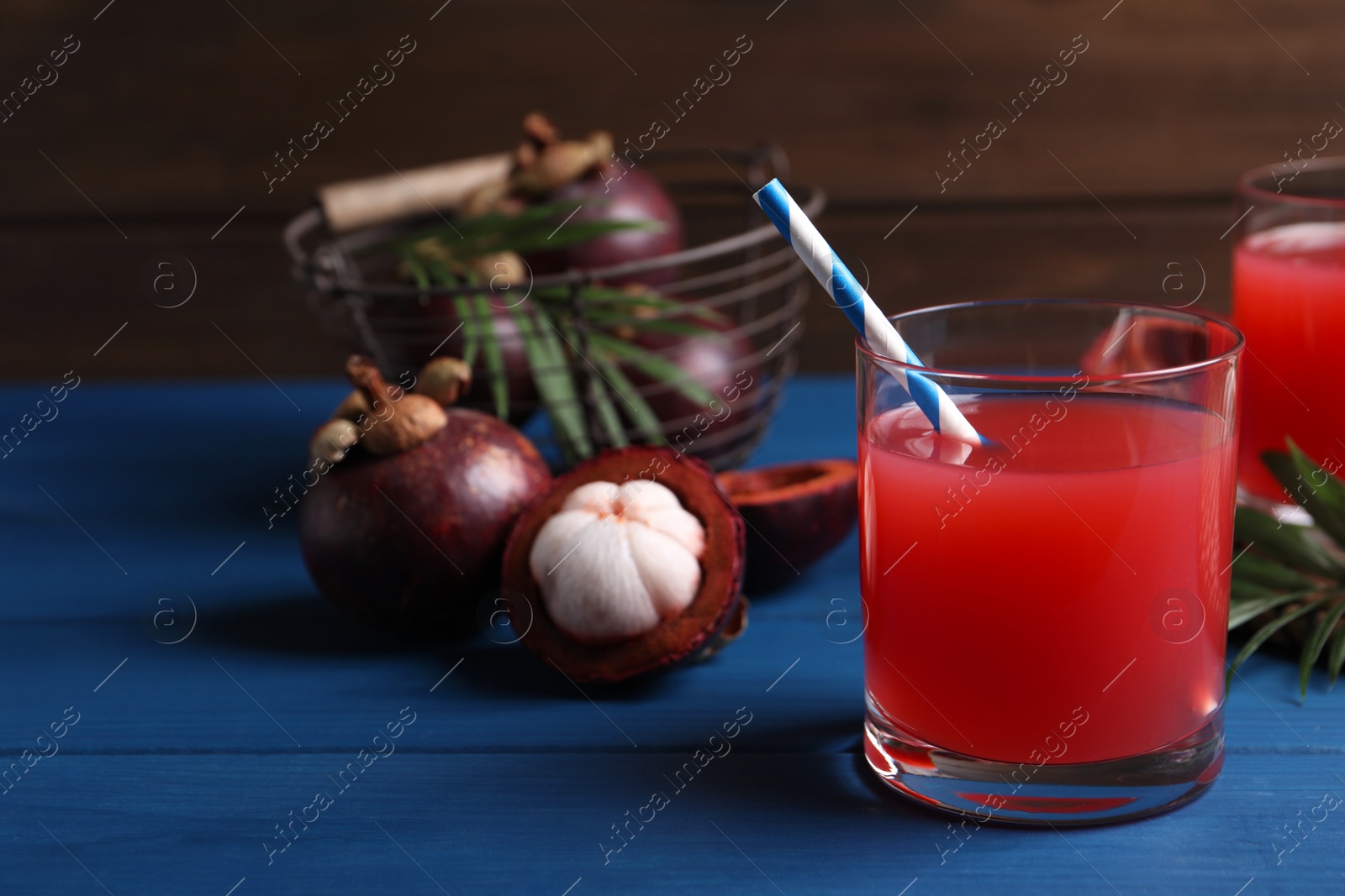 Photo of Delicious fresh mangosteen juice on blue wooden table