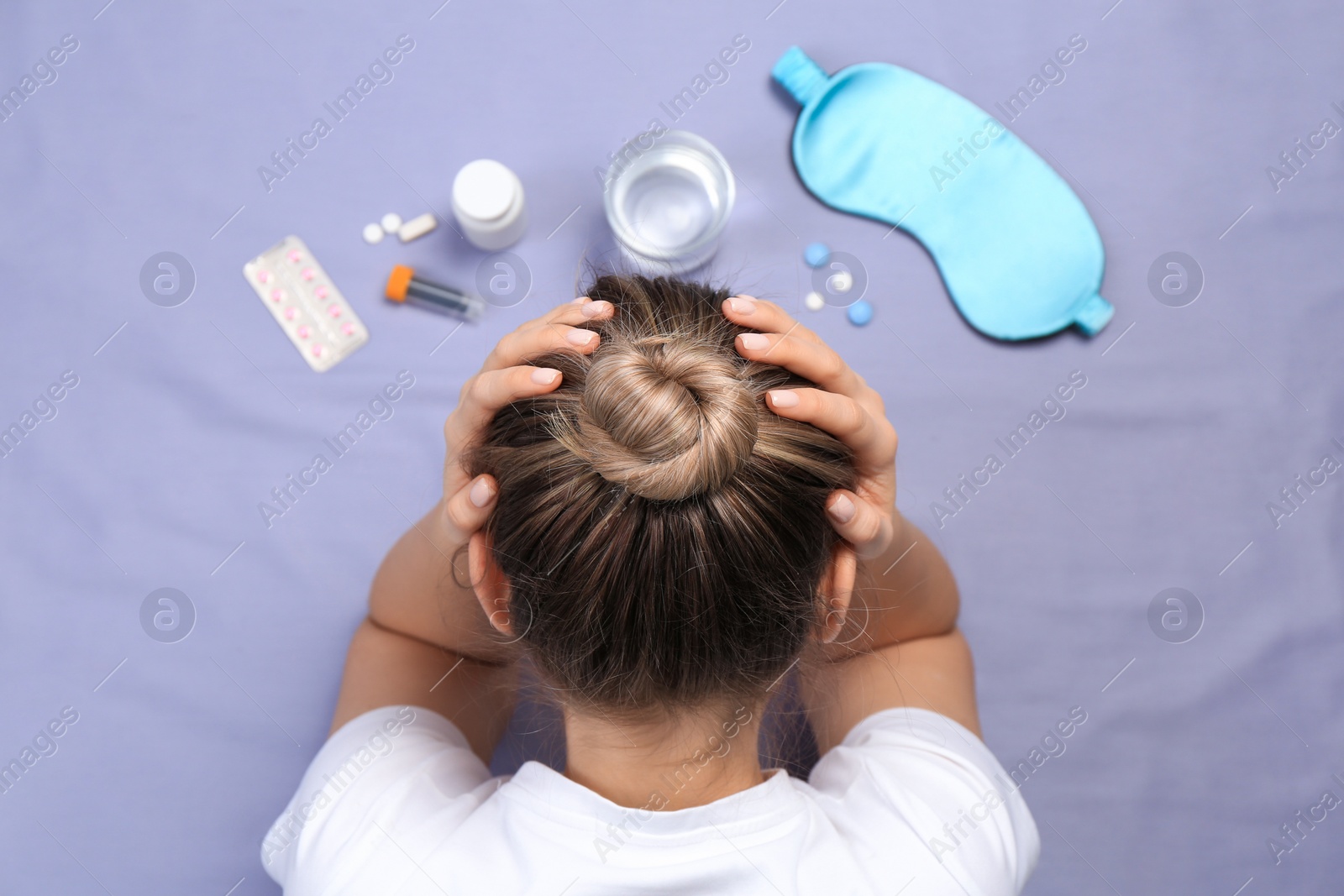 Photo of Woman surrounded by different pills on bedsheet, top view. Insomnia treatment