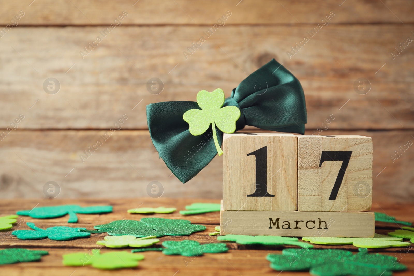 Photo of Composition with block calendar on wooden table, space for text. St. Patrick's Day celebration