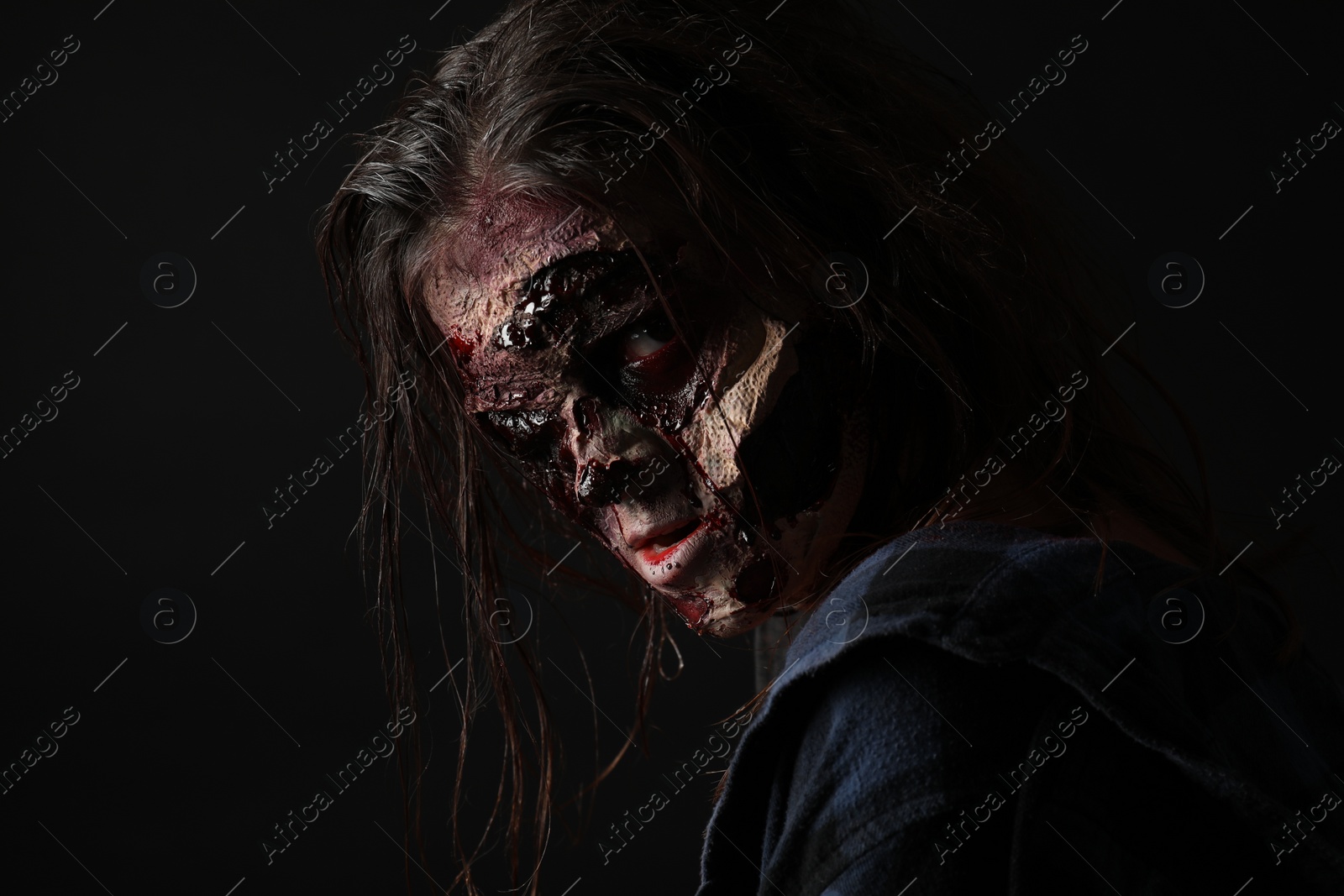 Photo of Scary zombie on dark background. Halloween monster