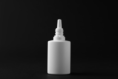 Photo of Bottle of nasal spray on black background