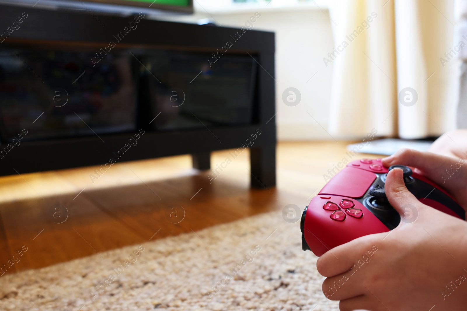 Photo of Child playing video games with controller at home, closeup. Space for text