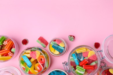 Tasty jelly candies in jars on orange background, flat lay. Space for text