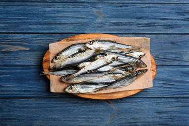 Tasty dried fish on blue wooden table, top view