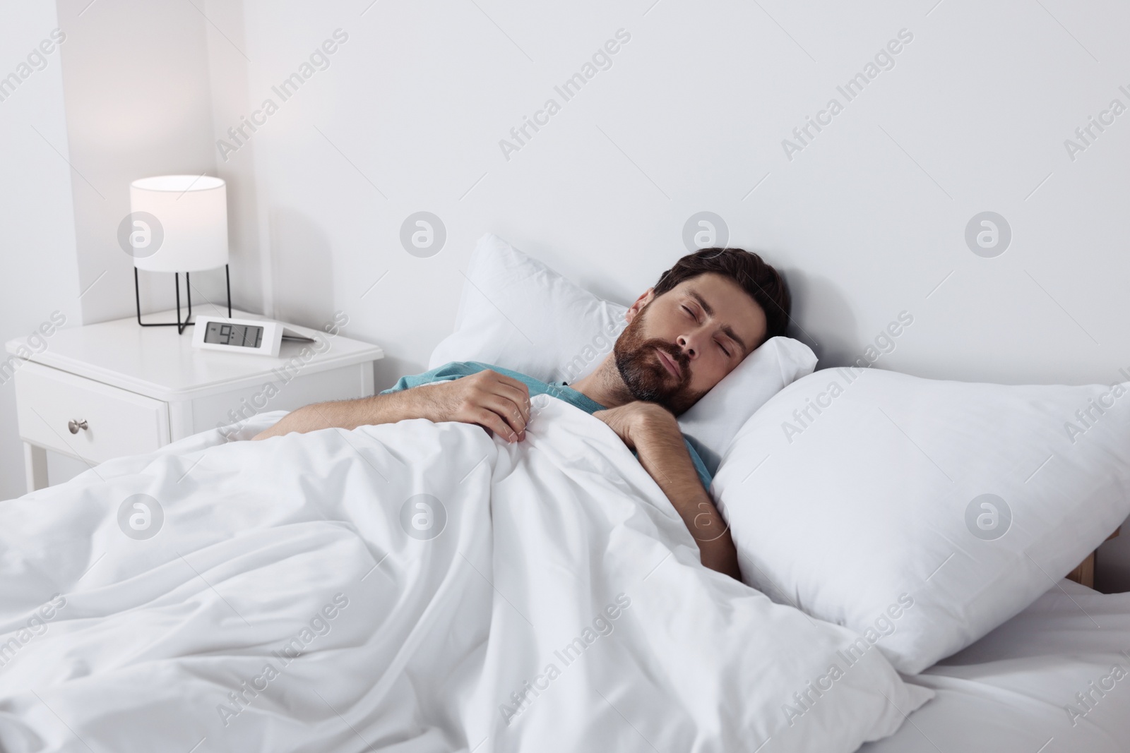 Photo of Man sleeping on comfortable pillows in bed at home