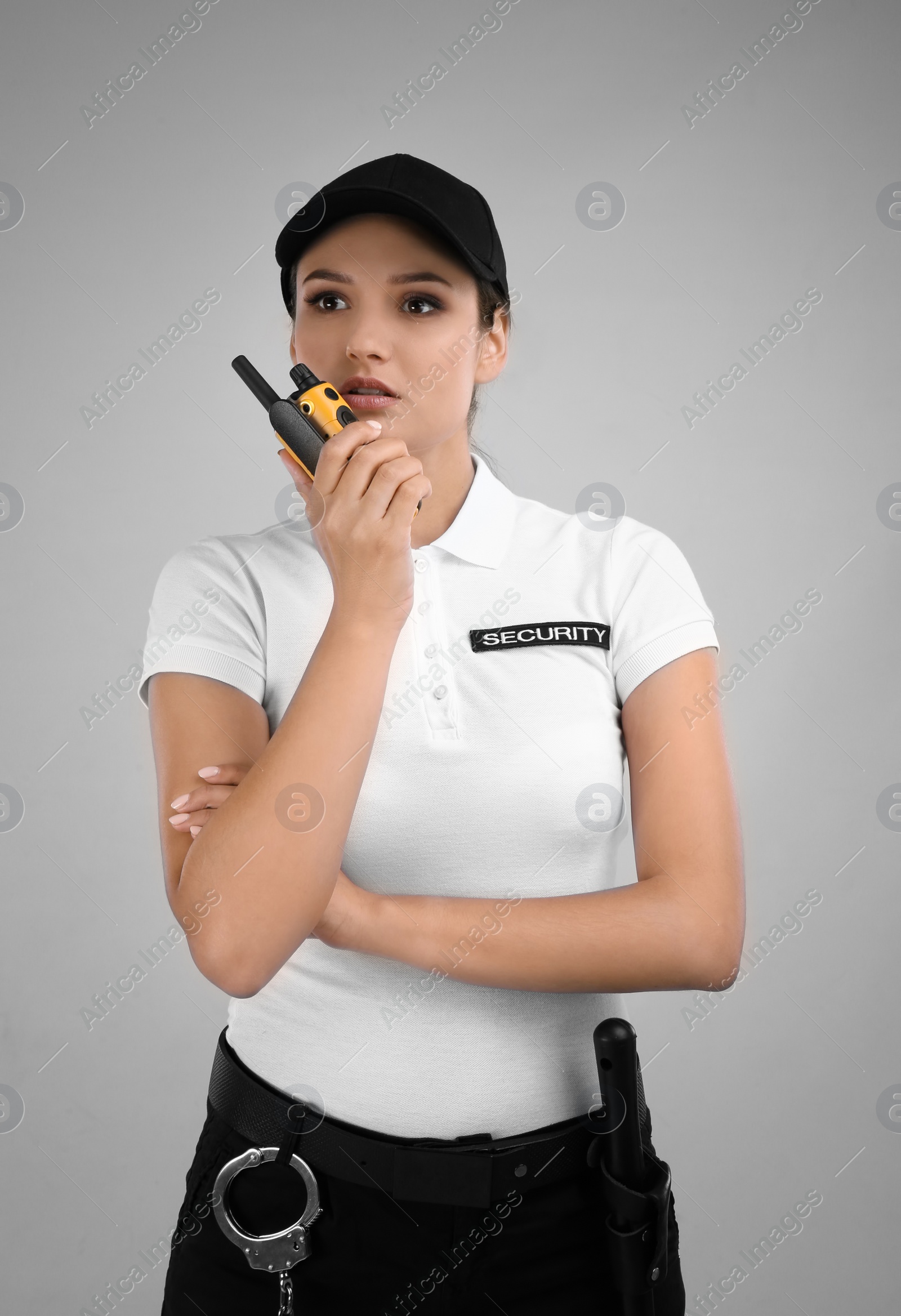 Photo of Female security guard using portable radio transmitter on color background