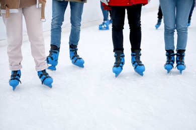 Image of Group of friends skating at outdoor ice rink, closeup
