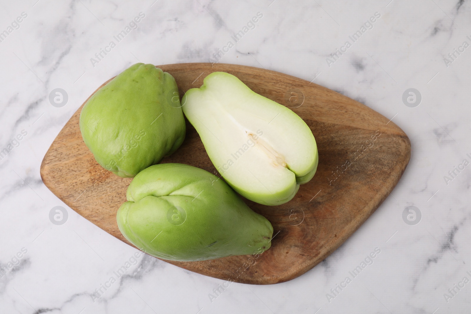 Photo of Fresh green chayote on light marble table, top view