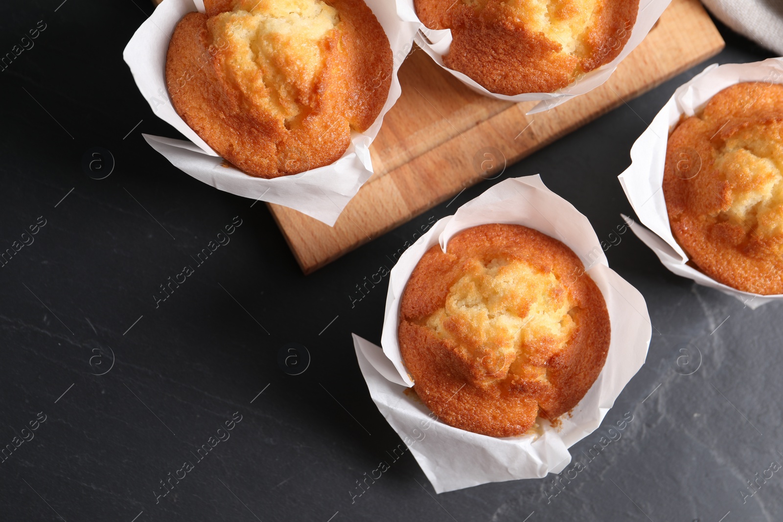 Photo of Tasty muffins on grey table, flat lay. Space for text