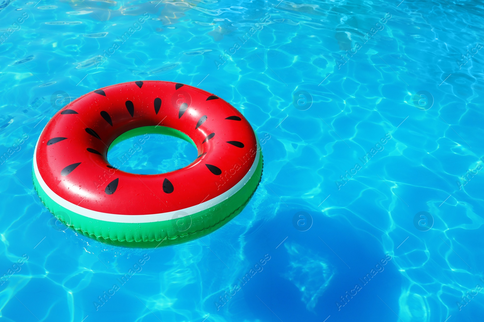 Photo of Inflatable ring floating in swimming pool on sunny day. Space for text