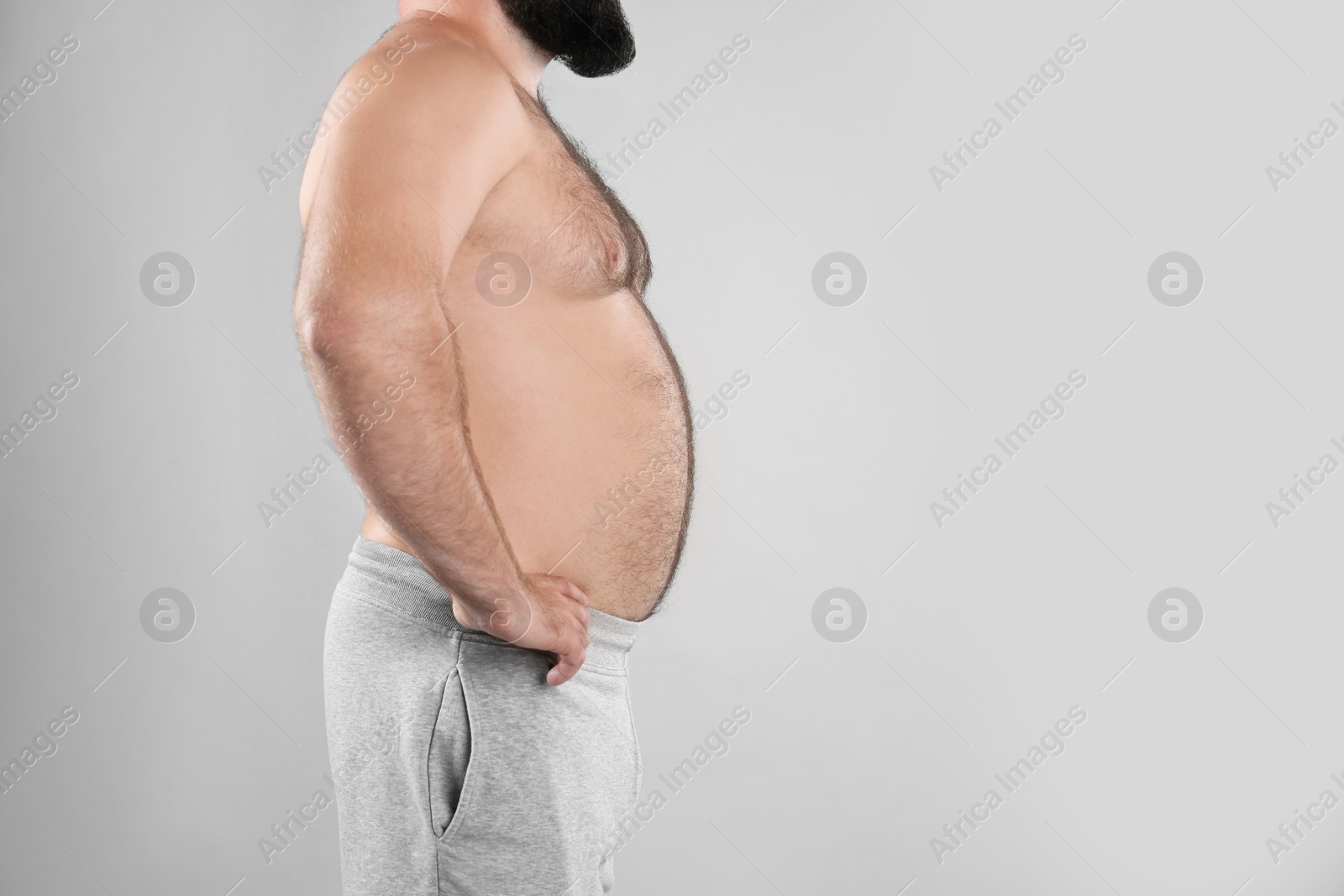Photo of Fat man on grey background, space for text. Weight loss