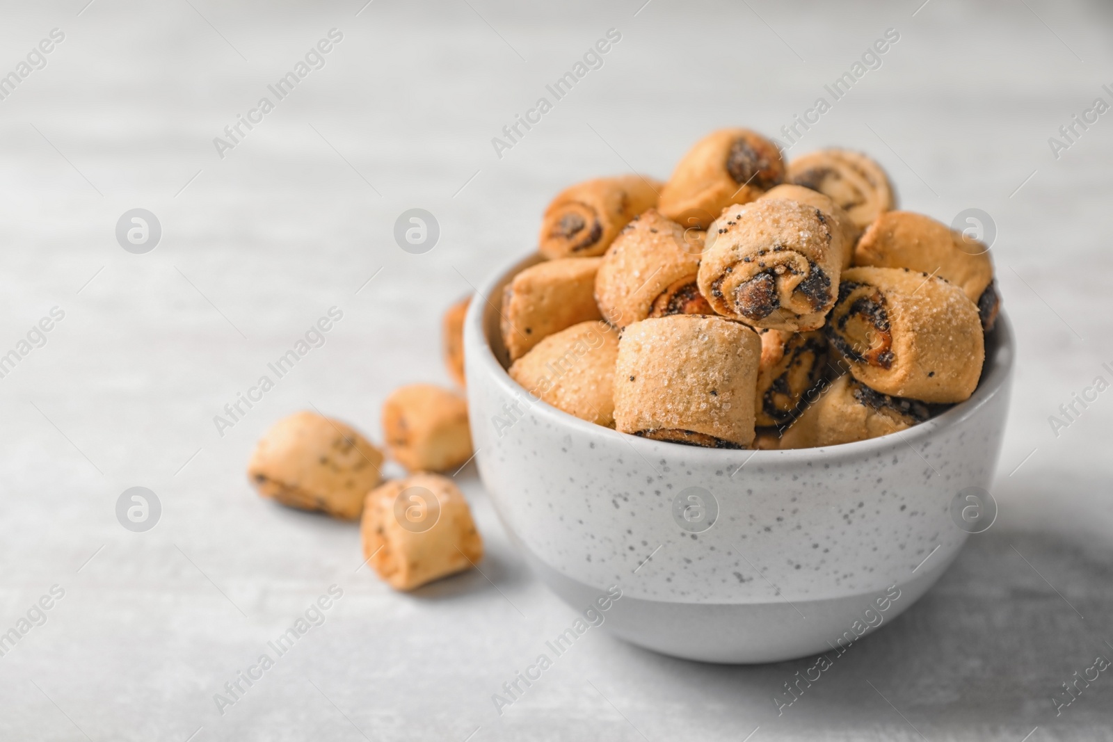 Photo of Tasty sweet cookies with poppy seeds on gray table. Space for text