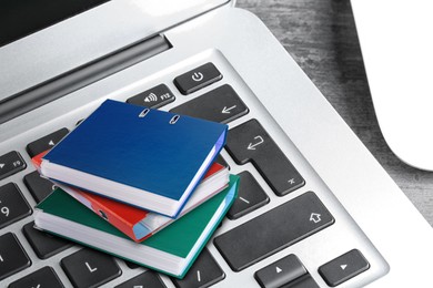 Image of Digital archive. Laptop keyboard with stacked downsized folders on table, closeup