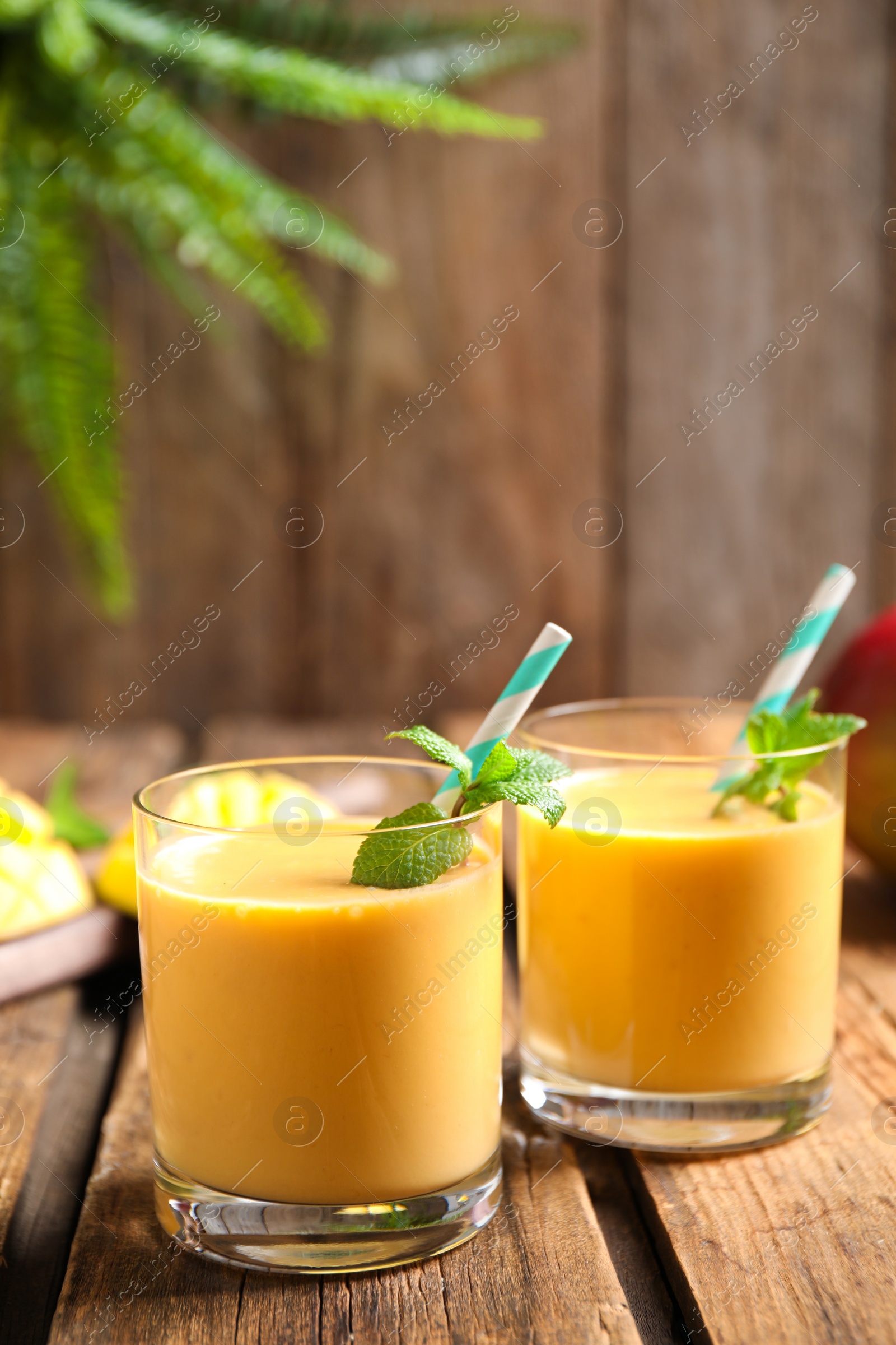 Photo of Fresh delicious mango drink on wooden table