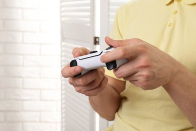 Photo of Man using wireless game controller indoors, closeup. Space for text