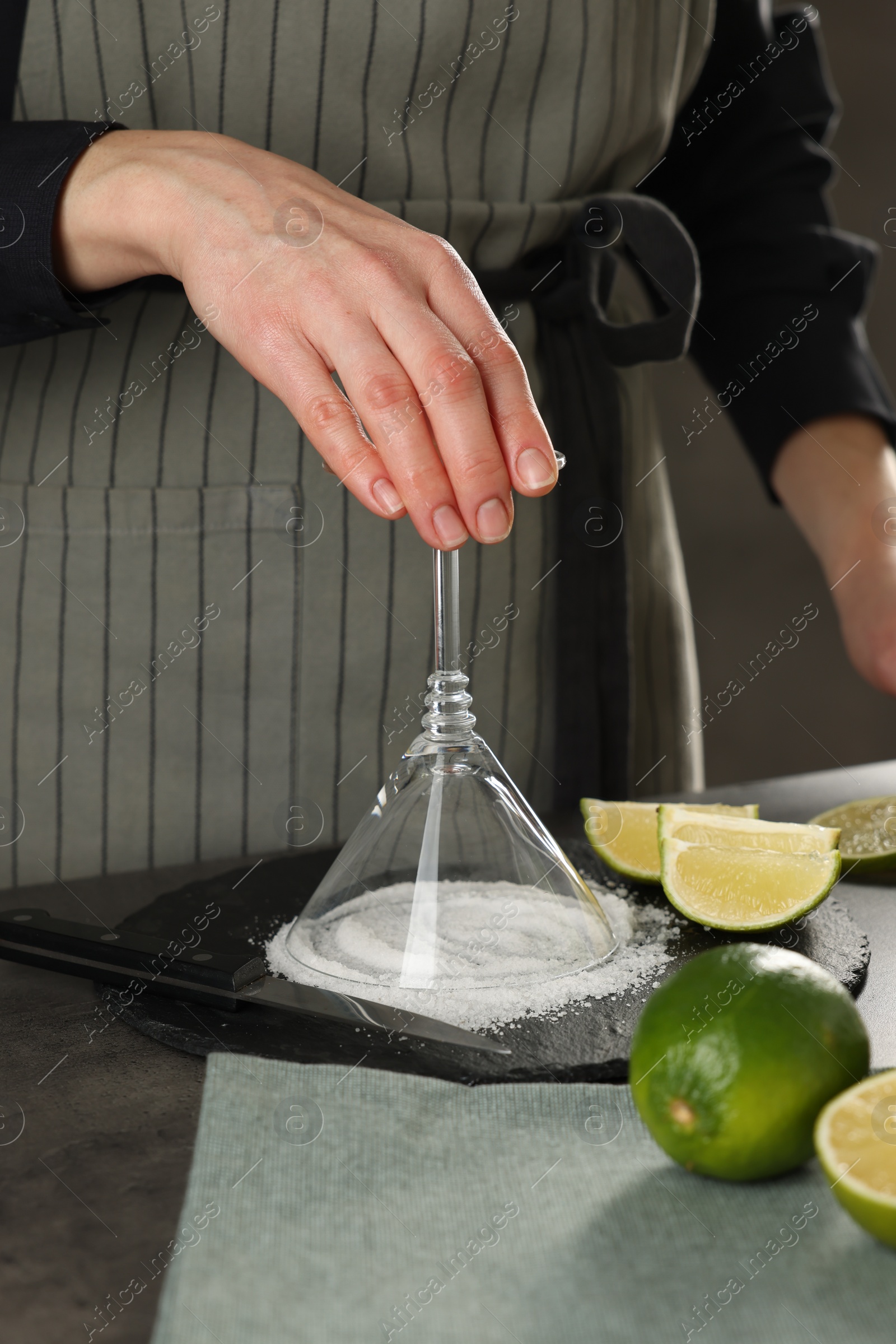 Photo of Woman making delicious Margarita cocktail at grey table, closeup