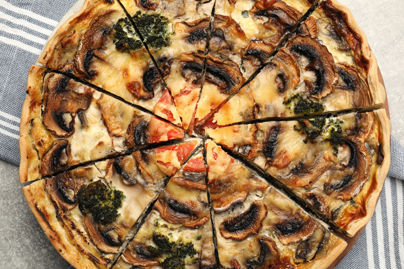 Photo of Delicious quiche with mushrooms on grey table, closeup