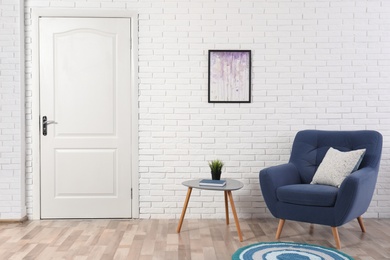 Photo of Light room interior with white door in brick wall