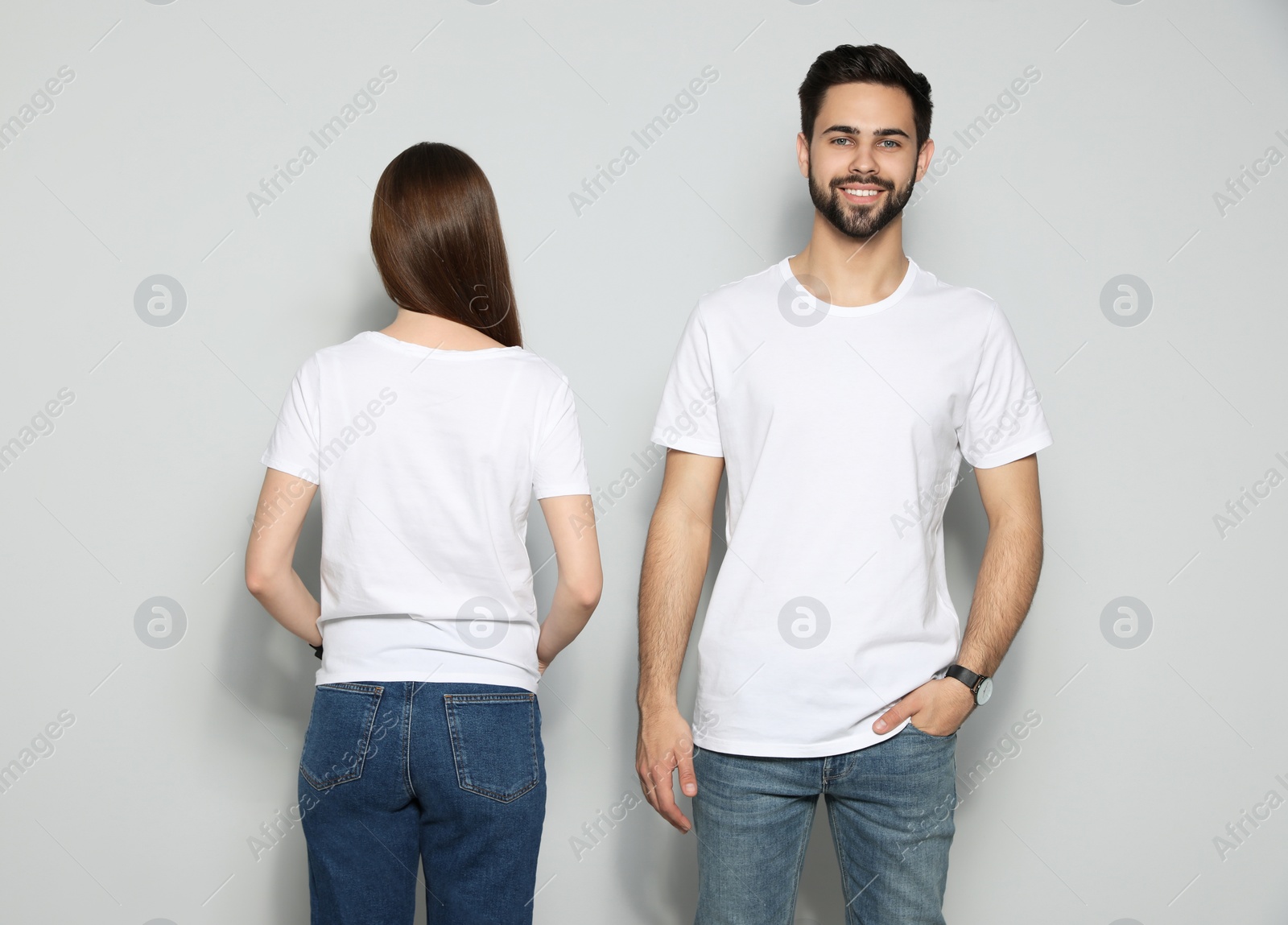 Photo of Young people in t-shirts on light background. Mock up for design