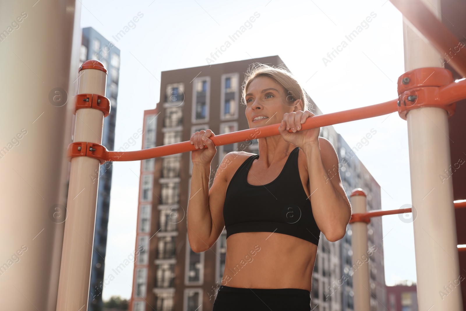 Photo of Woman doing pull ups at outdoor gym