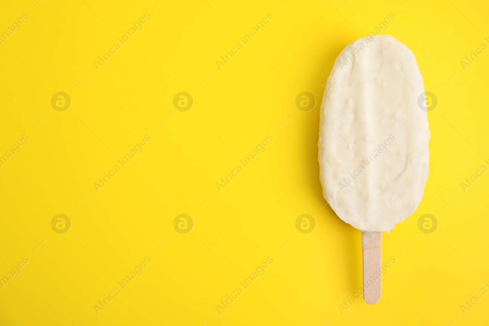Photo of Ice cream with glaze on yellow background, top view. Space for text