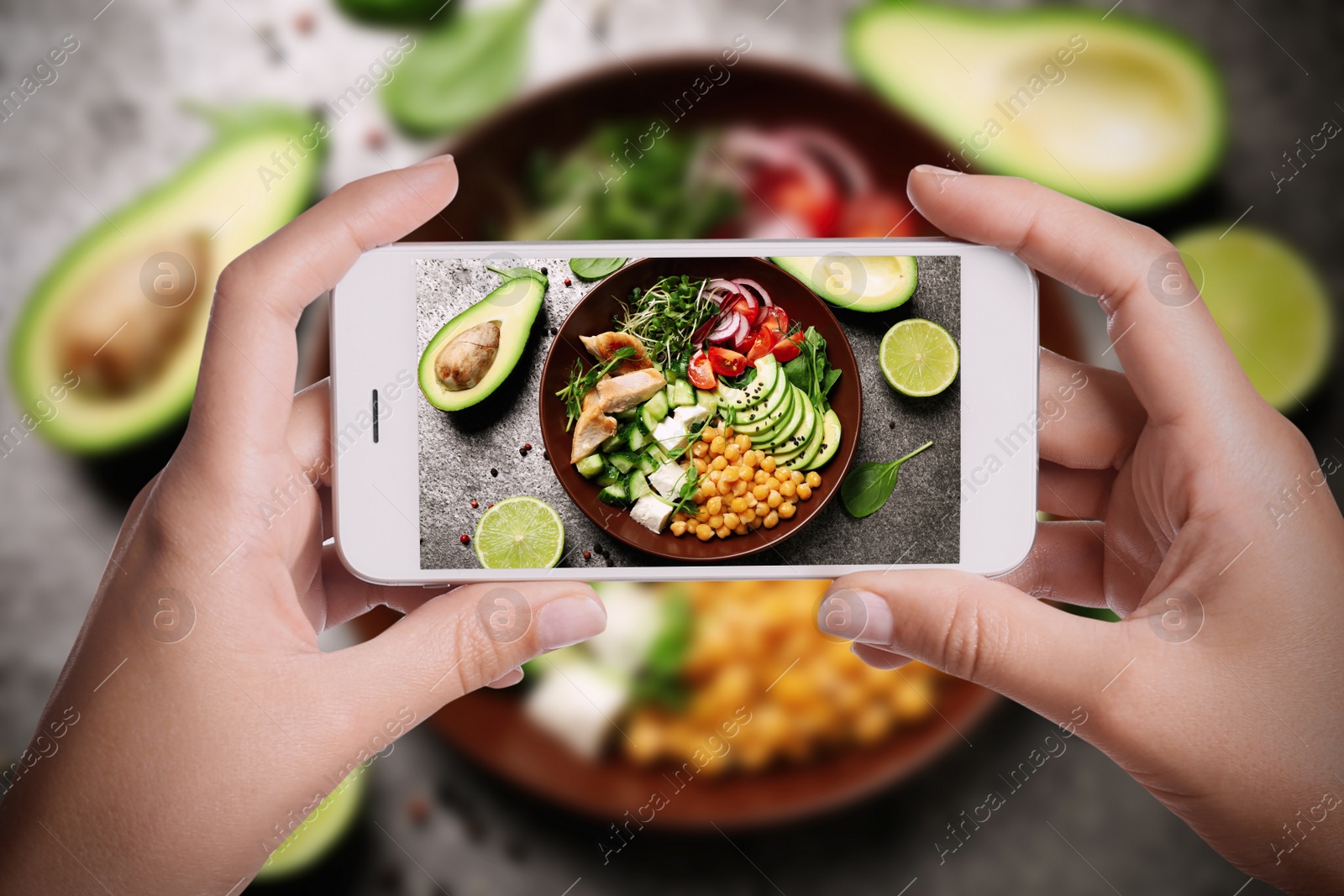 Image of Blogger taking picture of delicious salad with chickpea at table, closeup. Food photography