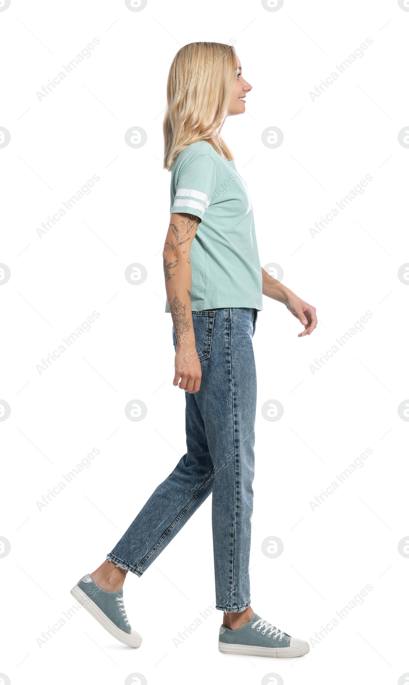 Photo of Beautiful young woman walking on white background