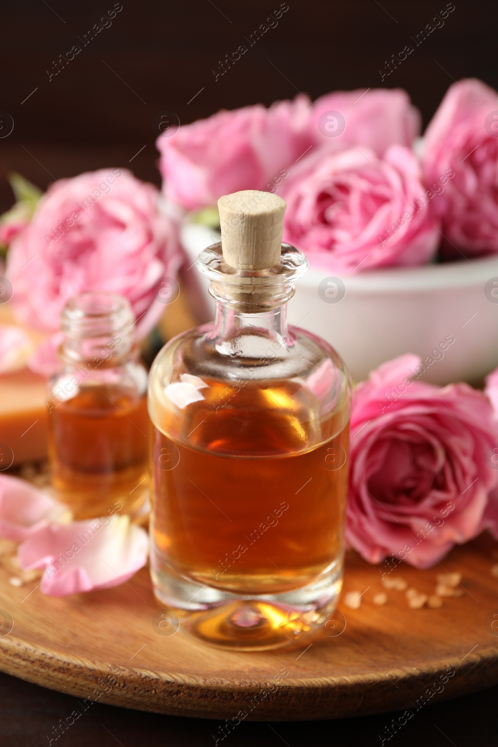 Photo of Composition with aroma oil on wooden tray, closeup