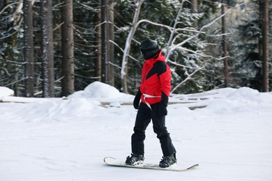 Photo of Man in suit snowboarding on hill. Winter vacation