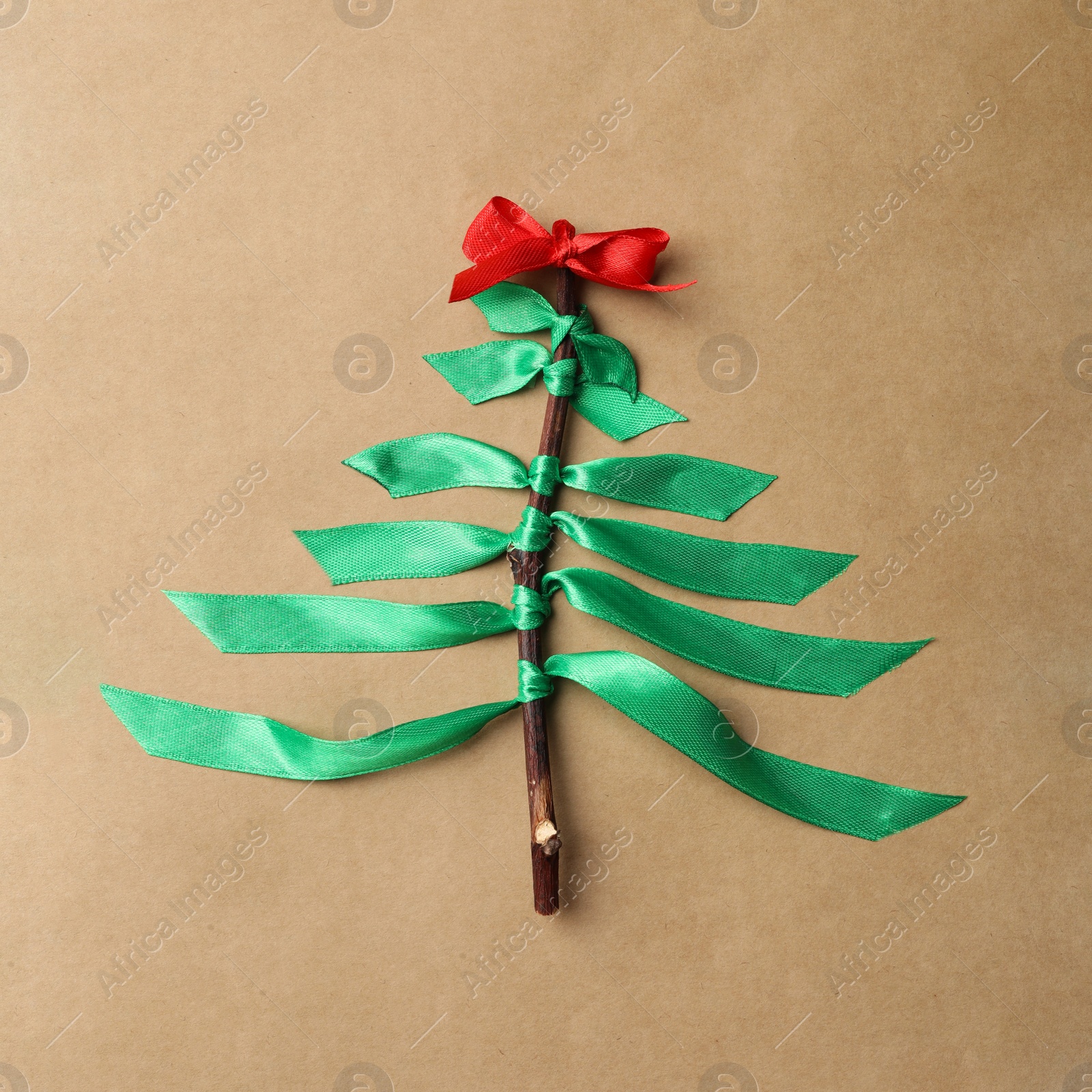 Photo of Christmas tree made of ribbons on kraft paper, top view