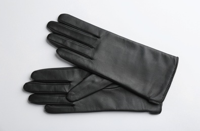 Pair of stylish leather gloves on white background, flat lay