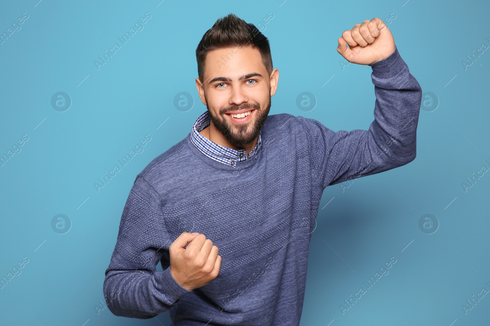 Photo of Happy young man celebrating victory on color background