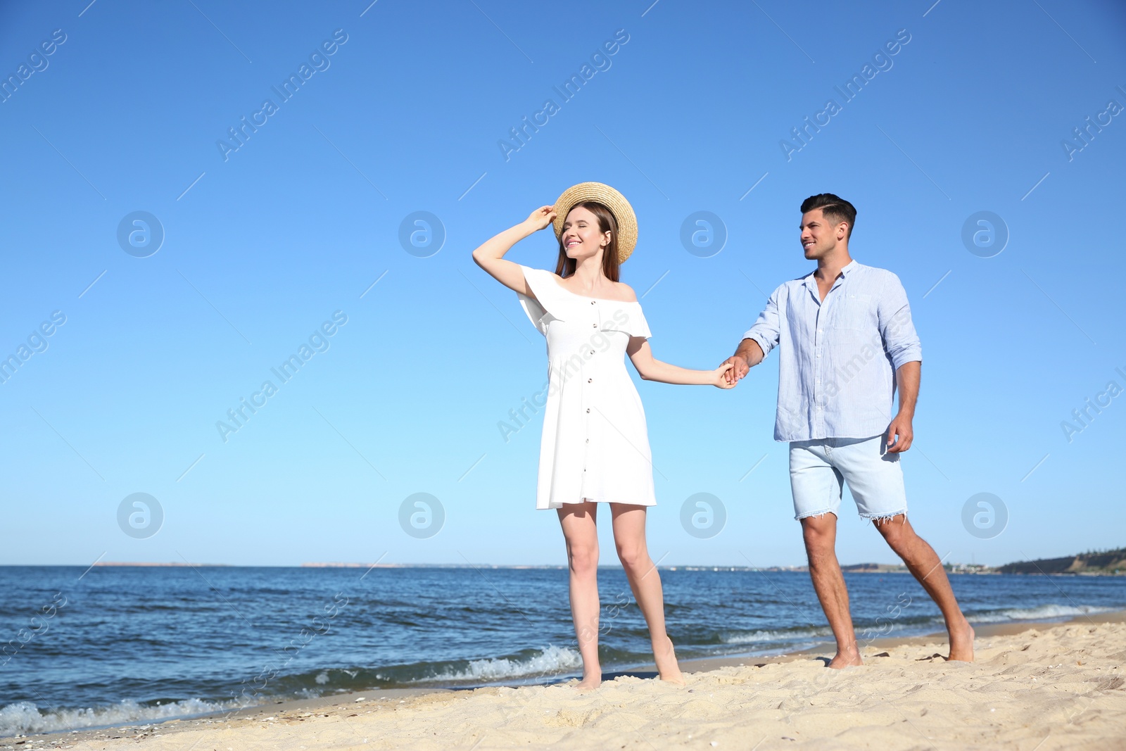 Photo of Lovely couple walking on beach. Space for text