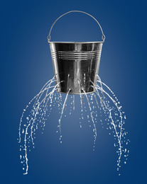 Image of Leaky bucket with water on blue background 