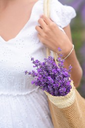 Photo of Woman with bag of beautiful lavender flowers outdoors, closeup