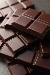 Photo of Delicious dark chocolate on grey table, closeup