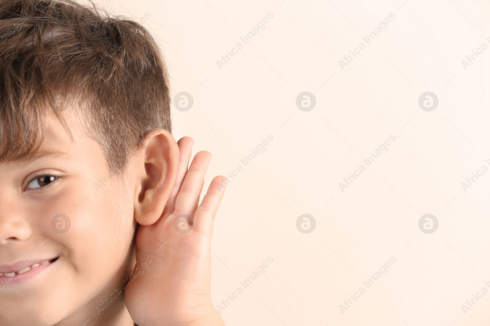 Photo of Cute little boy with hearing problem on light background, closeup. Space for text