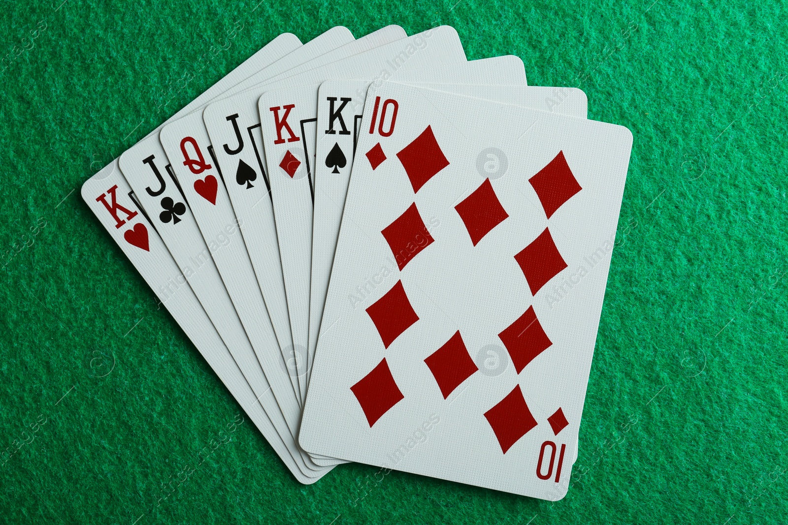 Photo of Playing cards on green table, top view