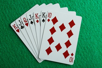 Photo of Playing cards on green table, top view