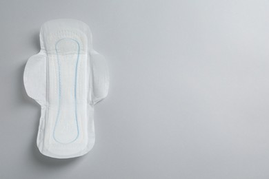 Photo of Sanitary napkin on light grey background, top view. Space for text