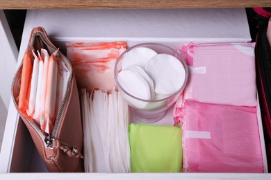 Photo of Open cabinet drawer with different menstrual pads, above view