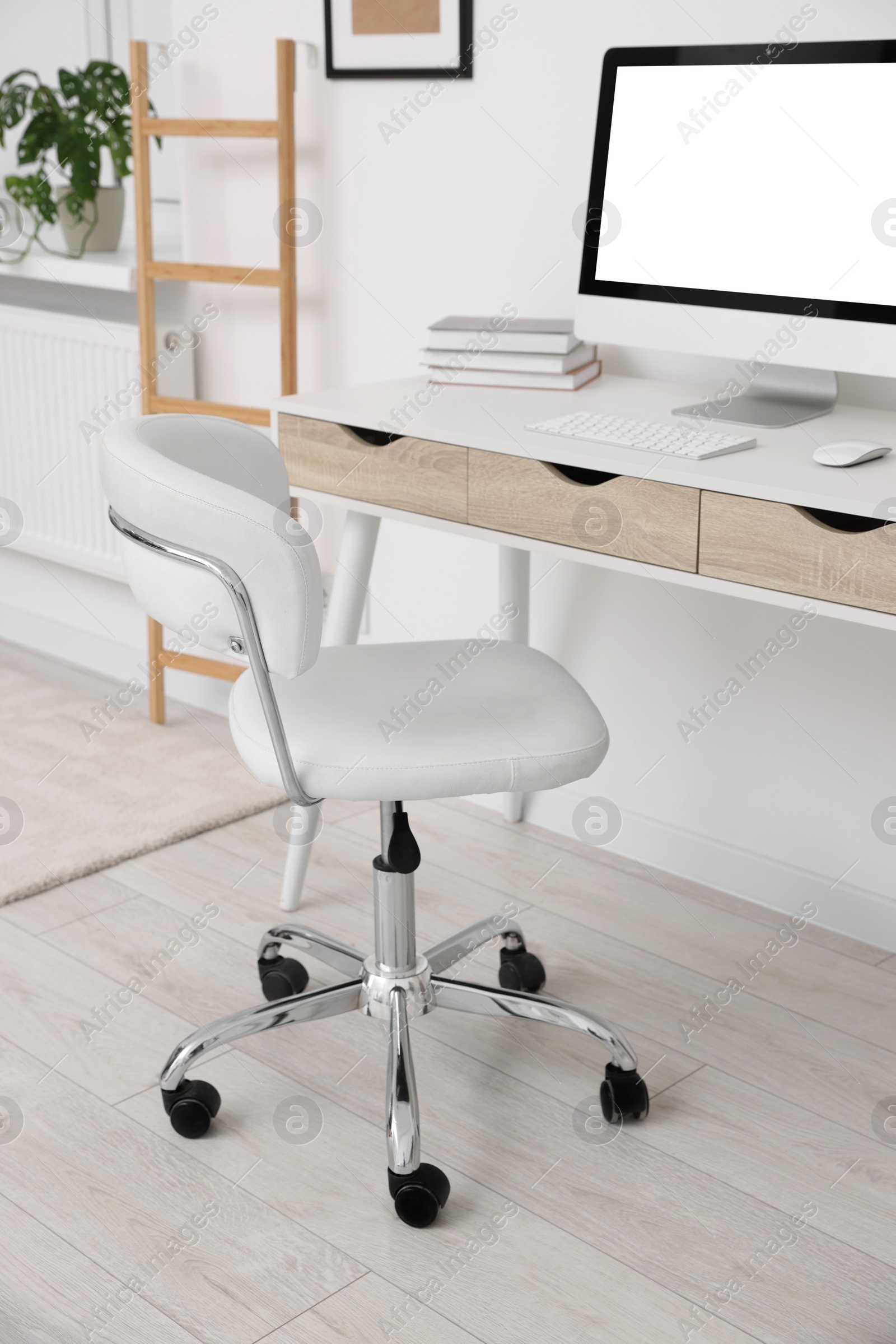 Photo of Workplace with comfortable office chair indoors. Interior design