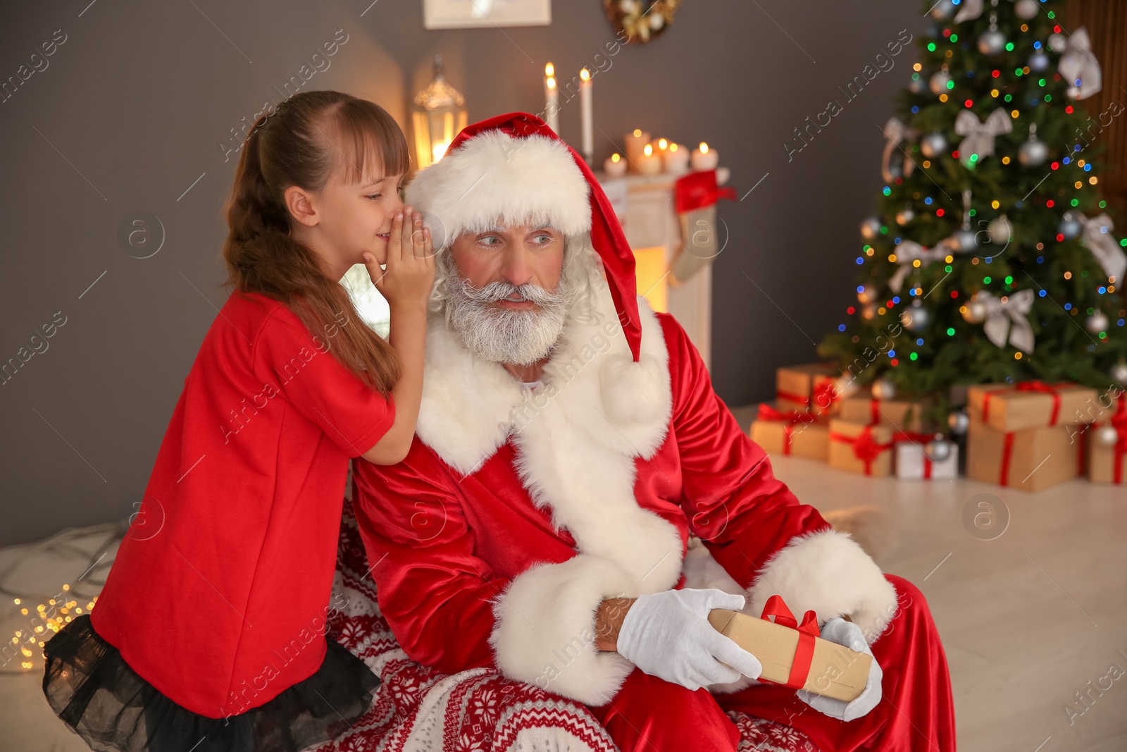 Photo of Little child with Santa Claus and Christmas gift at home