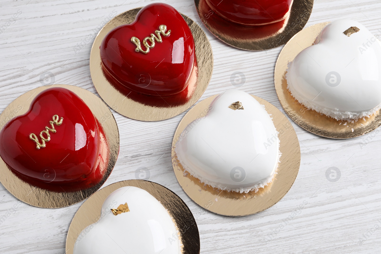 Photo of St. Valentine's Day. Delicious heart shaped cakes on white wooden table, above view