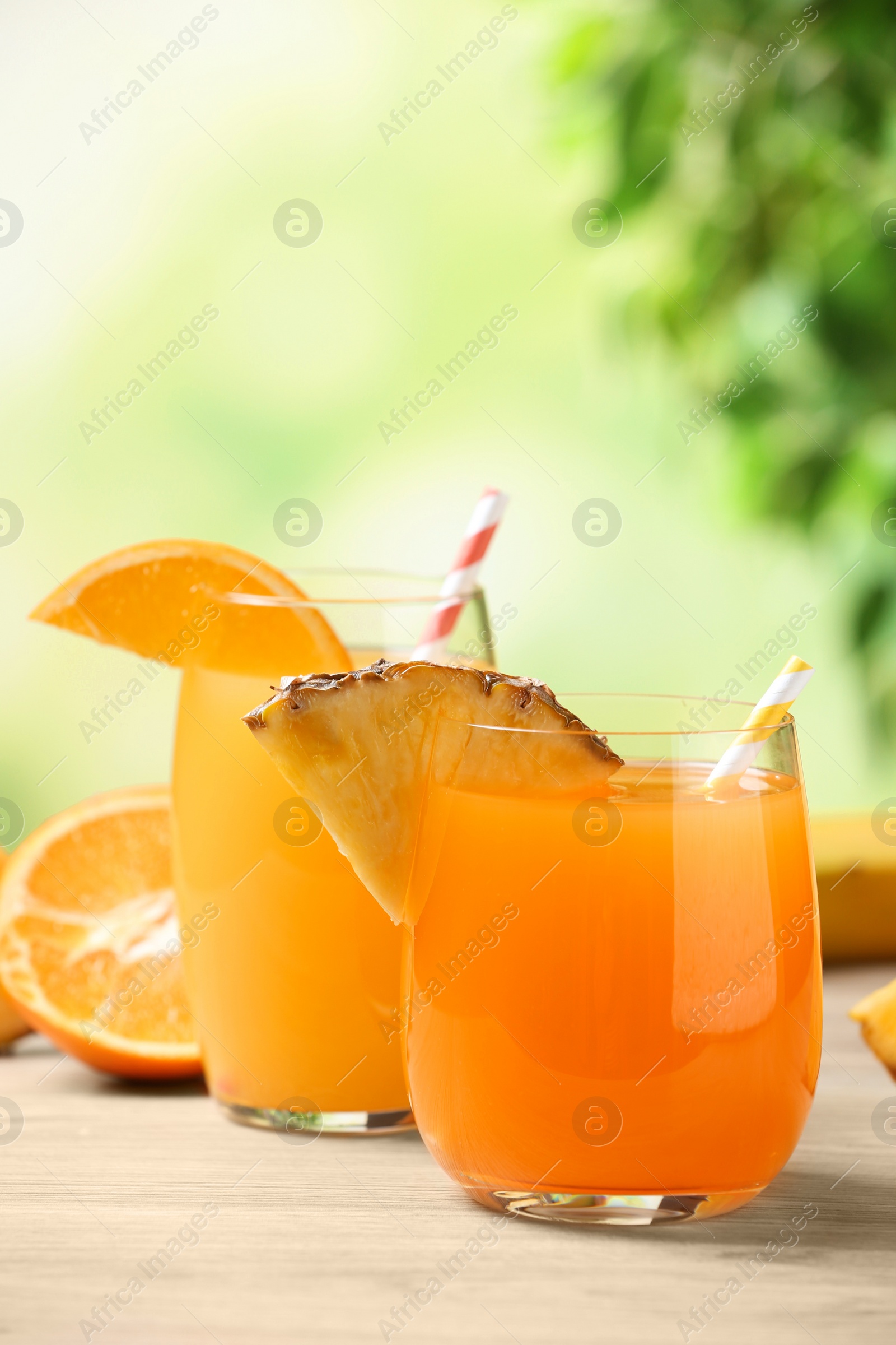 Photo of Pineapple and orange juices in glasses on white table