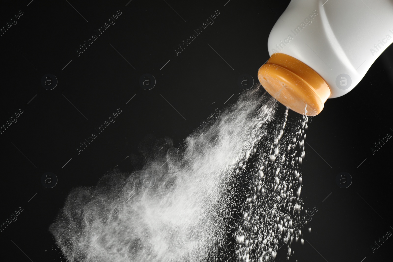 Photo of Scattering of dusting powder on black background