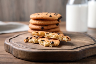 Photo of Delicious cookies with chocolate on wooden board